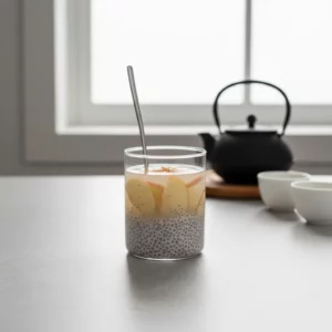 Adding apple slices into a glass of soaked chia drink.