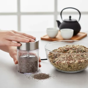 Grinding roasted seeds in a small grinder beside a bowl of seed mix.