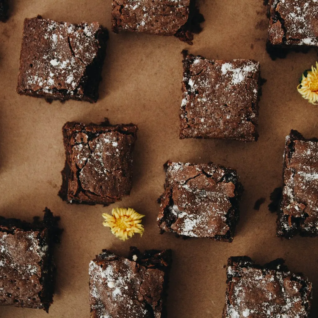 Small-batch chocolate brownies dusted with powdered sugar on parchment paper
